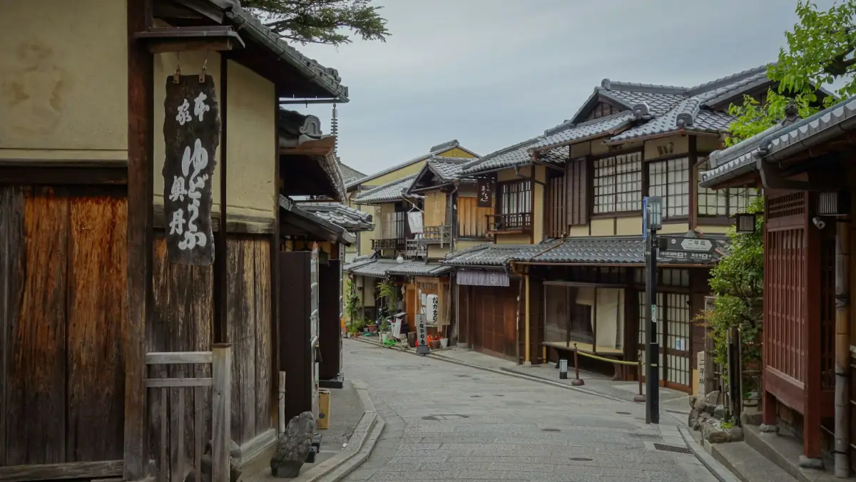 A quiet Kyoto street lined with traditional wooden townhouses.
